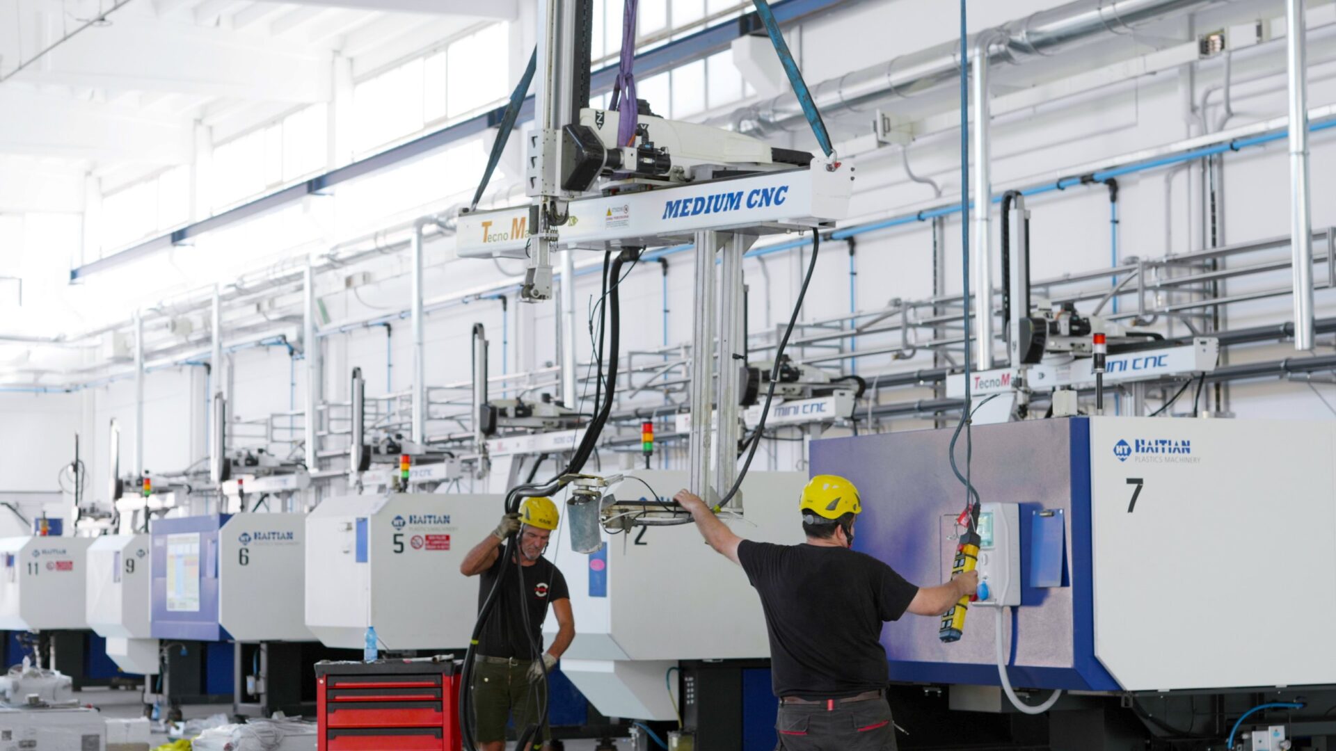 Robot cartesiano sollevato sopra le presse a iniezione
